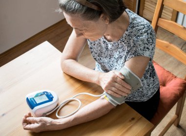 Yaşlı kadın evde oturuyor messure bood basıncı çok düşük normal