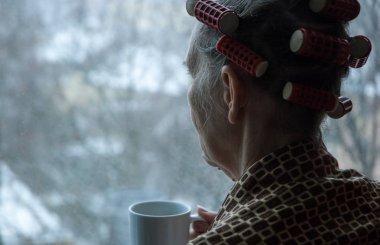  Üzgün, yalnız, yaşlı kadın. Pencere kenarına bak. Depresyonda.