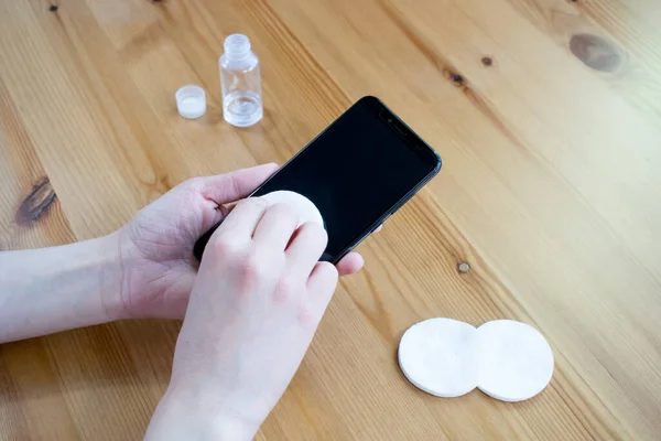 Best Way To Clean And Disinfect Your Sanitize Cell Phone, protect, phone on table closeup. hands hold smartphone.