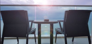 Bir deniz görünümü balkonda iki sandalye 