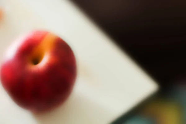 Manzana roja borrosa en plato blanco . —  Fotos de Stock