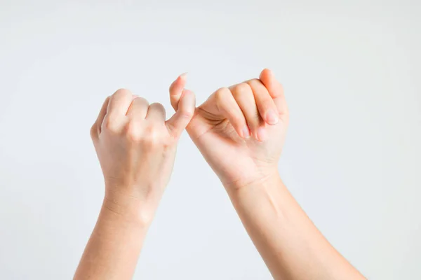 Zwei Hände haken kleinen Finger zusammen. — Stockfoto