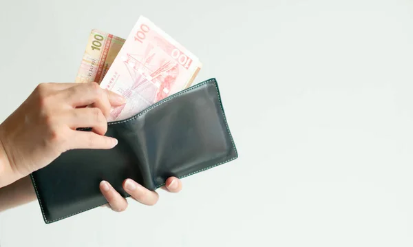 短い財布を持っている手のクローズアップともう一つの手は 財布から100ドル香港 Hkd の価値を持つ香港のお金の2銀行券を持ってきます — ストック写真