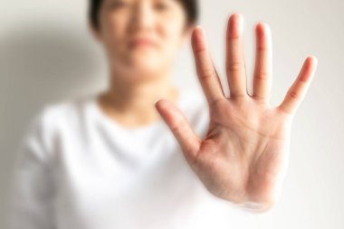 Bir kadın kolunu kaldırır ve beş parmaklı bir avuç içi gösterir. Bu işaret ya da vücut dilidir. Lütfen dur, hayır de ya da yasakla, beyaz arka planda sadece avuca odaklan..