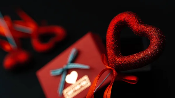 Een Cadeau Voor Valentijnsdag Tussen Glanzende Rode Harten Een Zwarte — Stockfoto