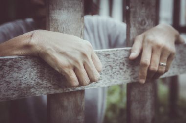 Kadın el tünemiş ahşap çit: ceza kilitli hapiste açıklaması - kullanılan seçici odak, vintage renk efekti için bekliyor