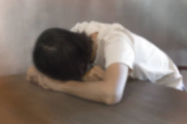 blurred image of sad woman alone in a room - sad concept