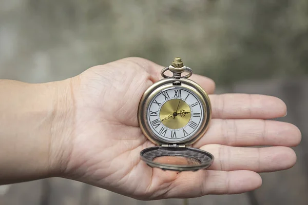close up of hands with vintage pocket watch