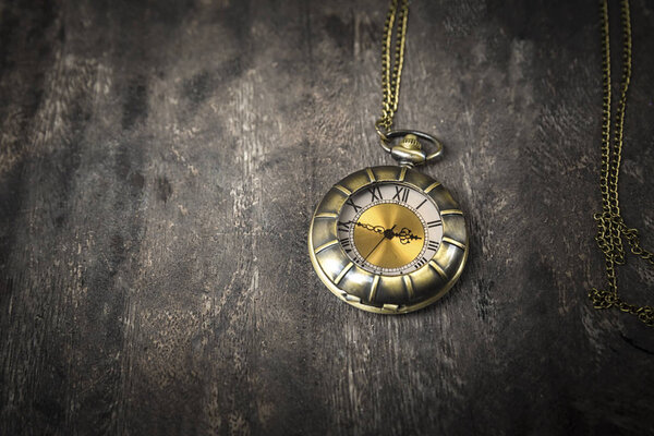 натюрморт с карманными часами на гранжевом деревянном столе: винтажный стиль
