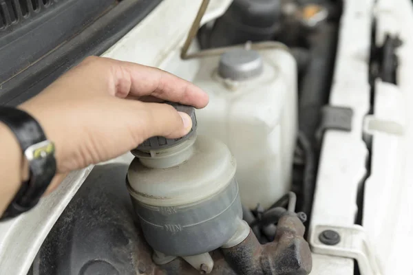 man's hand checking level of brake fluid tank - Car maintenance