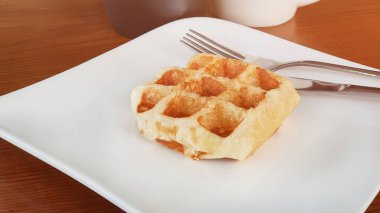 Tahta masada beyaz bir tabakta bal waffle sandviçi. Eski tarz bir resim.