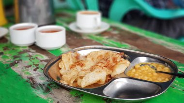 Myanmar 'da fasulye püresi soslu metal tabakta vejetaryen roti canai: Hint tarzı sokak yemeği