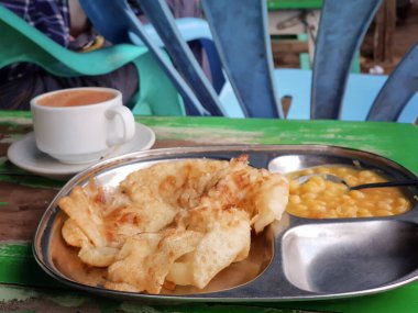 Myanmar 'da fasulye püresi soslu metal tabakta vejetaryen roti canai: Hint tarzı sokak yemeği