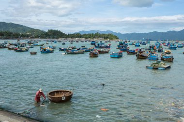 Geleneksel eski ahşap Vietnamca tekneler ve yuvarlak balıkçı tekneleri Mulk Chai. Yerel dokuma bambu sepet tekneler veya turlayan harbour palamarla. Vietnam