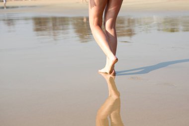 Kumsalda yürüyen bir kadın