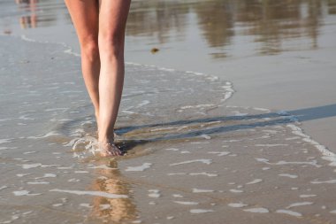 Kumsalda yürüyen bir kadın