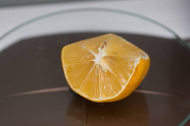 Limon. Mutfak masasında ince kabuklu bir dilim limon var.