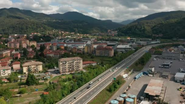 Widok z lotu ptaka. Samochody poruszają się na drodze mostu autostrady w górach nad doliną wsi. — Wideo stockowe