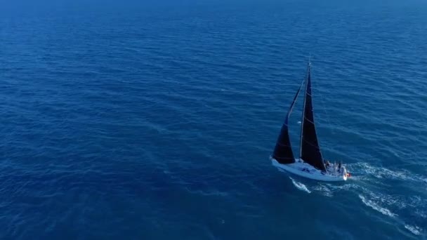 Légi felvétel. Vitorlás jacht fehér vitorlákkal a nyílt tengeren. — Stock videók