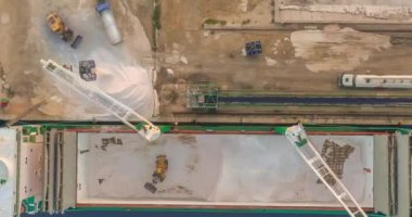 Hava görüntüsü. Gemi limana vardı. Geminin içindeki bir kazıcı tarafından kargo gemisinin boşaltılması. Zaman Uygulaması.