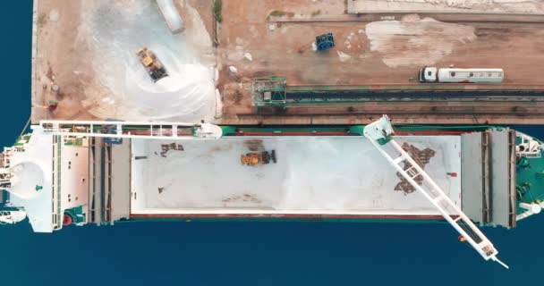 Flygfoto. Skeppet anlände till hamnen. lossning av lastfartyg med grävmaskin inne i fartyget, lossning av bulklast. — Stockvideo