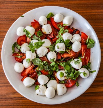 Yuvarlak bufalo mozzarella topları ve fesleğen İtalya klasiği ile taze domates.