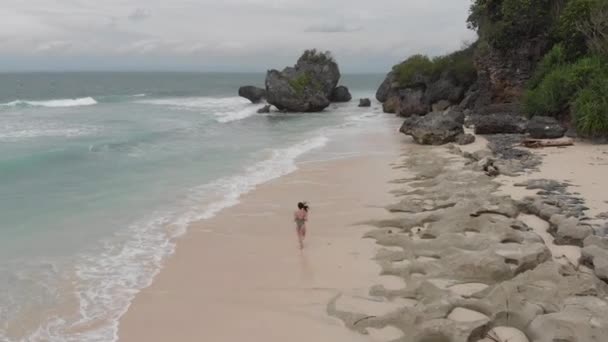 女孩在海浪边的沙滩上奔跑 — 图库视频影像