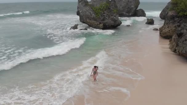 女孩在海浪边的沙滩上奔跑 — 图库视频影像
