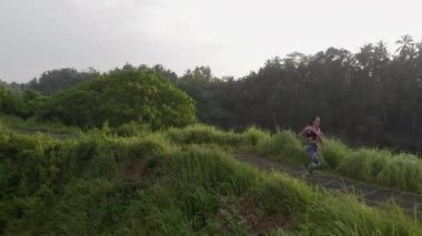 Tozlu kız gün doğumunda ormanda koşuyor.