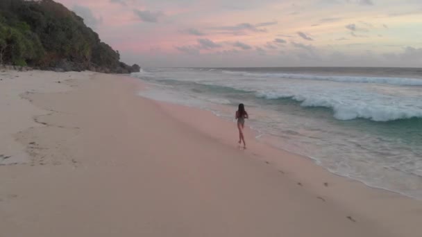 Een Meisje Een Badpak Loopt Bij Zonsondergang Het Zandstrand — Stockvideo