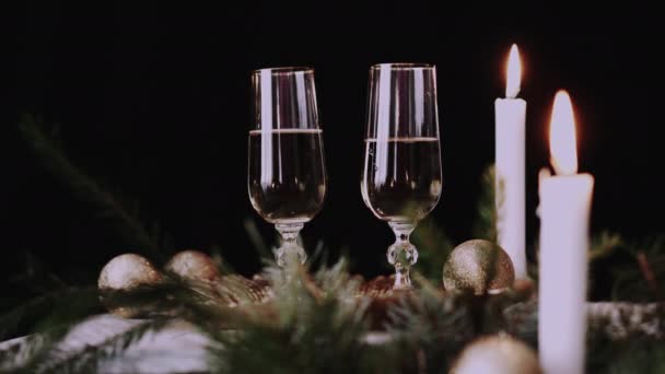 女性的手拿着一杯带有香槟 圣诞节装饰背景和蜡烛的杯子 — 图库视频影像