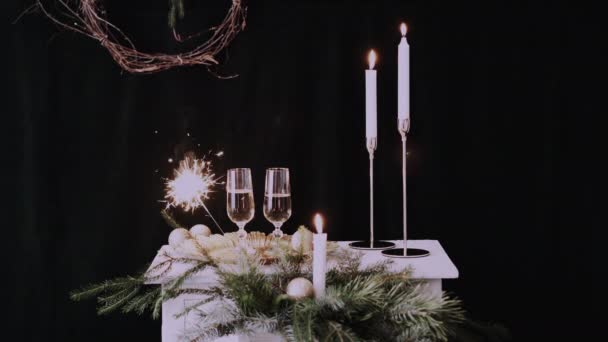 クリスマスの装飾が施されたシャンパン付きの2つのガラス 輝く背景とキャンドル — ストック動画