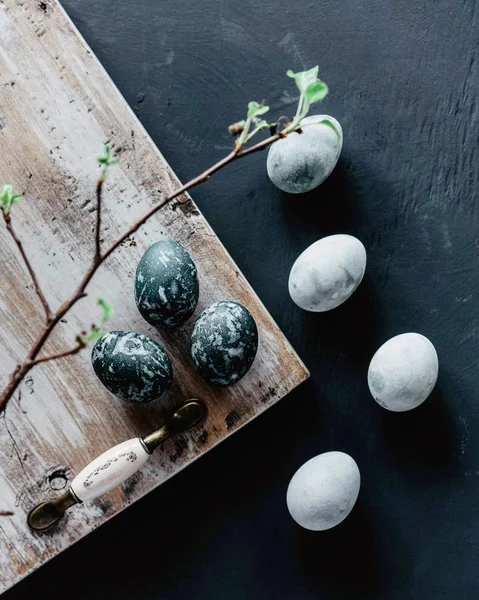 Os ovos de Páscoa pintados estão em uma mesa preta — Fotografia de Stock