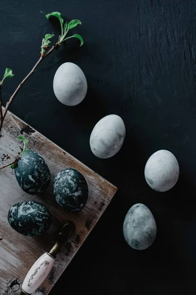 Os ovos de Páscoa pintados estão em uma mesa preta — Fotografia de Stock
