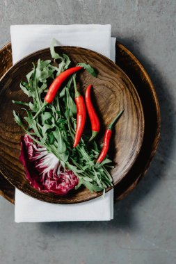 Tahta tabakta kırmızı biber, salata ve roka.