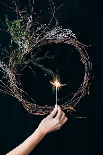 Kadın eli yanan bir maytap tutuyor.