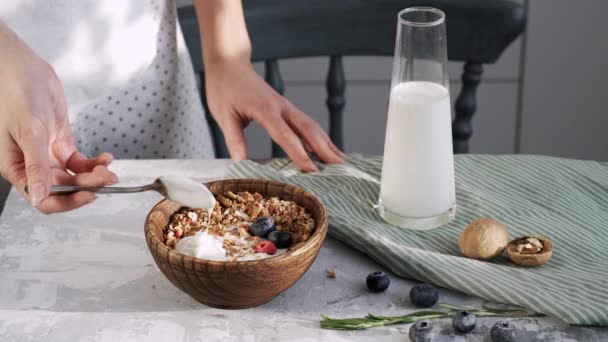 Kvinnlig Hand Gör Frukost Granola Och Vit Yoghurt Träplatta — Stockvideo