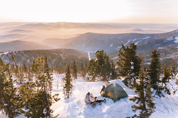Pareja en invierno en las montañas al atardecer — Foto de Stock