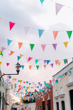 Meksika 'da sömürge bir İspanyol kasabasında pembe bir günbatımı gökyüzüne karşı renkli bayraklar