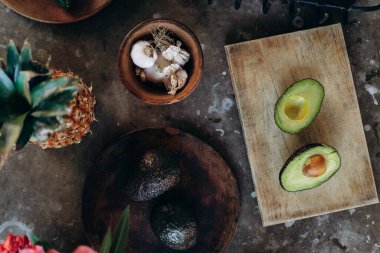 Avokado yarıları beton bir masanın üzerinde yatar.