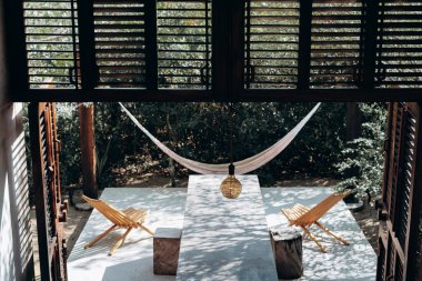 Ormanın ortasındaki evde beton masa ve hamaklar.