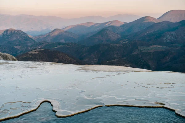 Meksika hierve del agua 'da mavi gölleri ve pınarları olan beyaz bir dağın tepesindeki kız.