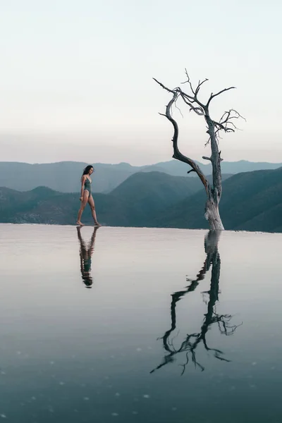 Meksika hierve del agua 'da mavi gölleri ve pınarları olan beyaz bir dağın tepesindeki kız.