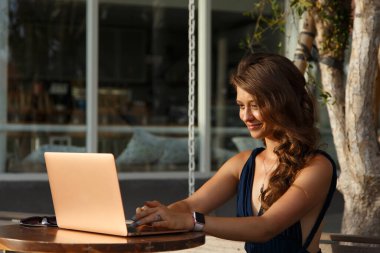 Dizüstü bilgisayarda çalışan kadın. Kullanılmış internet. Açık havada. Serbest çalışıyorum. Blogcu