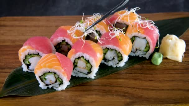 厨师正在日本餐馆做寿司卷 用芽装饰寿司 有鲑鱼 金枪鱼 黄瓜和鳄梨在木板上的Maki 靠近点 — 图库视频影像