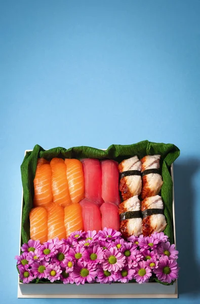 Sushi Set Med Blommor Presentförpackning Ljusblå Bakgrund Som Kreativ Chokladgodisask — Stockfoto