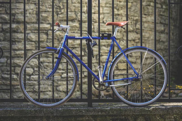 Niebieski Retro Rower Zaparkowany Przed Metalowym Ogrodzeniem Ceglanym Tłem Ściany — Zdjęcie stockowe