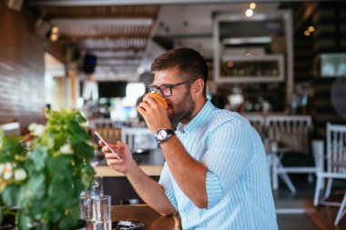 Bir yudum kahve üzerinden alarak