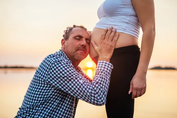 Objímání těhotné bříško — Stock fotografie