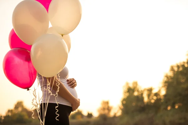 Těhotná žena hospodářství balóny — Stock fotografie